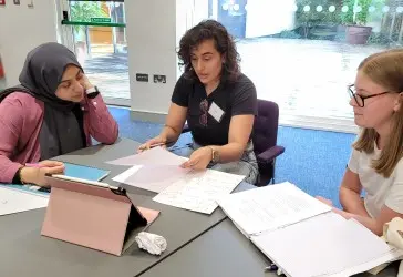 Arij discussing a mathematics problem with two students
